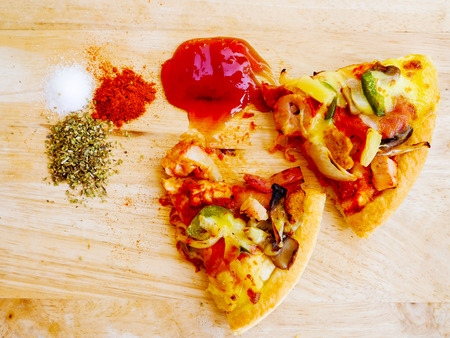 Pieces of pizza on wooden before mealsの写真素材