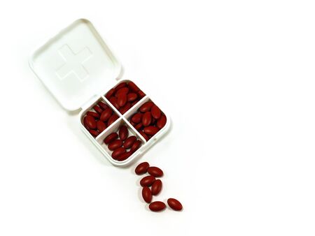 iron red pills in box isolated on white backgroundの写真素材