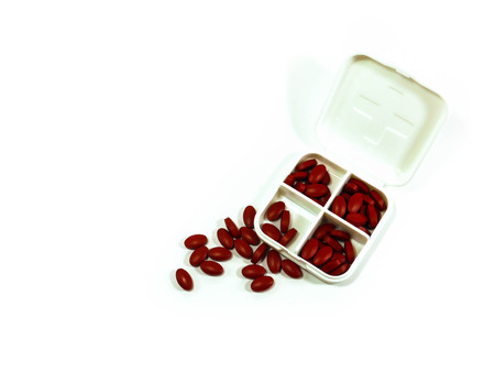 iron red pills in box isolated on white backgroundの写真素材