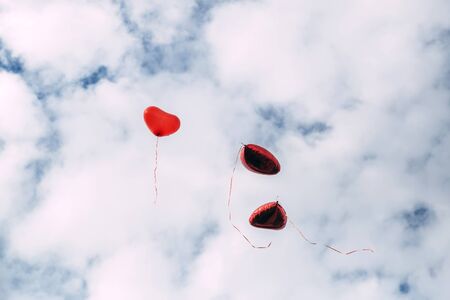 Heart shaped balloons flying in the sky.