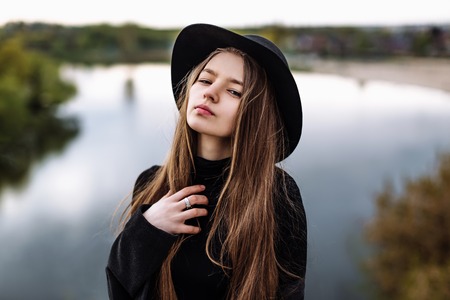 Young beautiful fashionable woman in hat, with long hair. Female fashion, beauty concept. Outdoor.の写真素材