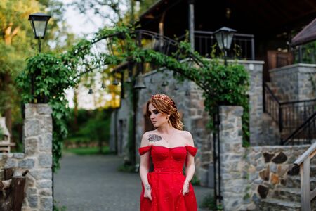 Redhead woman in red dress near the castleの写真素材