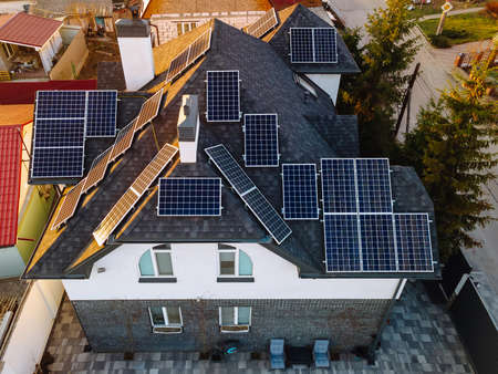 Aerial view of solar photovoltaic panels on a own house roof in small european city. Renewable green...