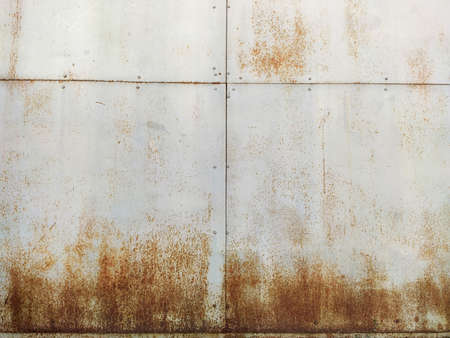 Corroded metal background. Rusted white painted metal wall. Rusty metal background with streaks of rust. Rust stains. The metal surface rusted spots. Rystycorrosion.の写真素材