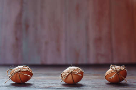Easter beige eggs decorate with rope on brown wooden backgroundの写真素材