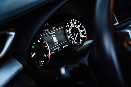 Close-up view of a modern car interior featuring illuminated digital instrument cluster and...