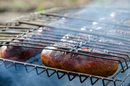Juicy sausages grilled over charcoal barbecueの写真素材