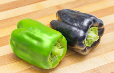 Black and green Bell pepper on a cutting boardの写真素材