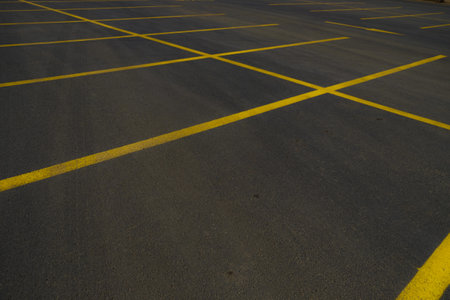 yellow lines in the big black asphalt international way, asphalt parking area, car parkの写真素材