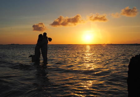 Couple in the sunset A couple wades in the water and dances in the sunset at Wing Beach, Saipan, Northern Mariana Islandsの写真素材