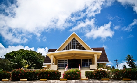 San Vicente Catholic Church with blue and white clouds, Saipan Façade of San Vicente Catholic Church in Saipan, Northern Mariana Islands, towered by white fluffy clouds on a sunny day.の写真素材