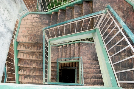 Outdoor spiral cement stairway at an abandoned building A spiral cement stairway going down to the...