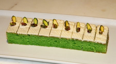 Green cake with white chocolate and walnut toppingの写真素材