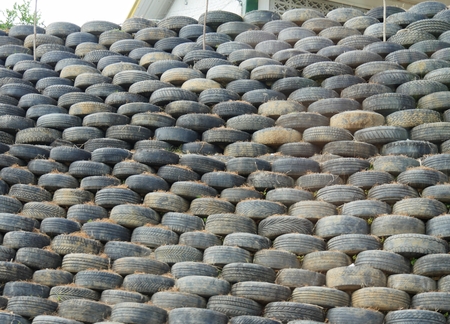A pile of old tires meticulously piled to serve as a fence