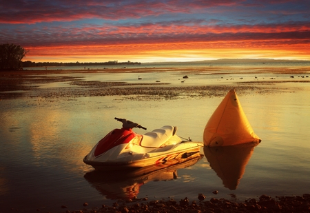 A jet ski is moored to the seaside at the Fishing Base in Saipan at sunset