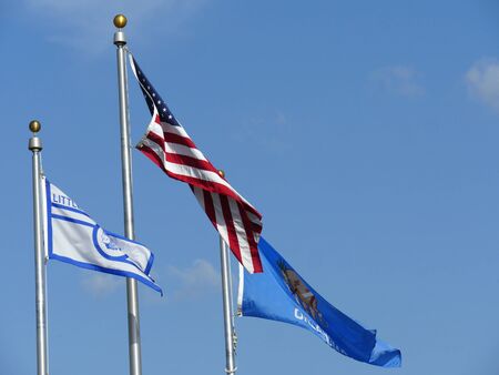Upward shot of the flags of the United States, Oklahoma State and Little Axe School in Oklahoma
