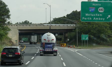New York, USA- September 2017: Directional signs on the interstate and vehicles going under an overpass approaching New York City.のeditorial素材