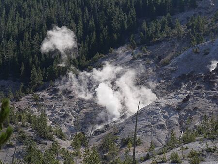 Medium close up of the Roaring Mountain with steam spewing from numerous fumaroles at Yellowstone National Park, Wyoming.の写真素材