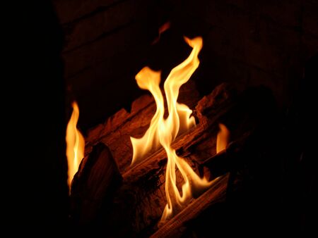 Hot flames from a log burning in a fireplaceの写真素材
