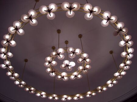 Upward shot of light bulbs in circular designs mounted on the ceiling
