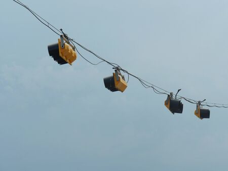 Old-fashioned traffic lights hanging by wires at an intersection