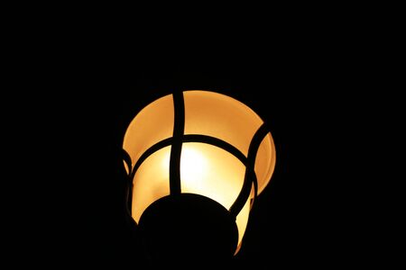 Upward shot of a ceiling lamp, dark background