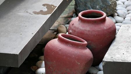 Two earthen jars surrounded with stones as decoration outdoorsの写真素材