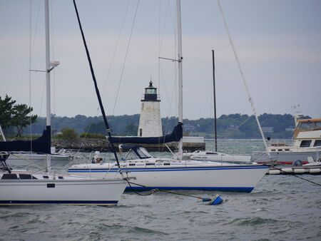 Newport, Rhode Island-September 2017: Boats at the Goat Island with the Newport Harbor Lighthouse in the background.のeditorial素材
