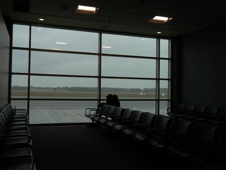 Warwick, Rhode Island-September 2017: Silhouettes of chairs and passengers at a predeparture area at  T.F. Green Airport in Warwick.のeditorial素材