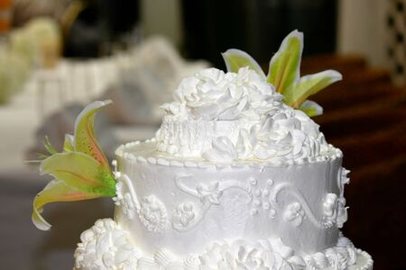 Top of a three- layer wedding cake with real flowers, soft background の写真素材