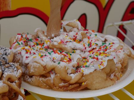 Close up of a birthday cake-flavored funnel cake with colored candy toppings の写真素材