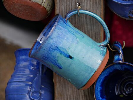 Hand-made, hand-painted ceramic mugs on display at a festivalの写真素材