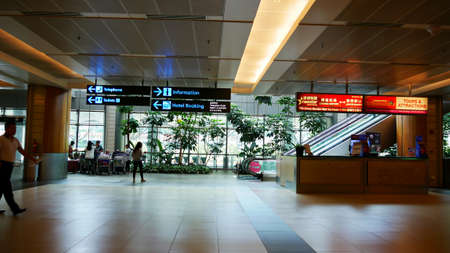 Singapore, Singapore-March 2016: Wide shot of the interior of Changi Airport Terminal 2 with a booth...