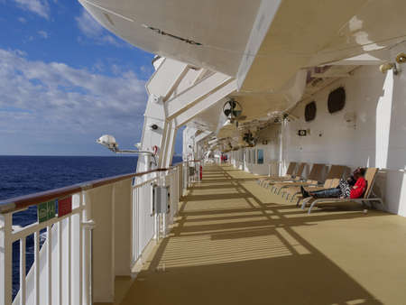 Miami, Florida- January 2018: A couple relaxes on the lounging chairs on deck of a cruise ship.のeditorial素材
