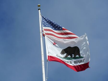 Medium close up shot of the State of California flag flying from a pole, cropped shot. の写真素材