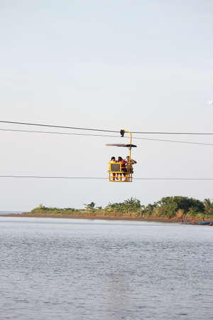 Surigao del Sur, Philippines- August 2014: A cable car with passengers in it floats above the river...