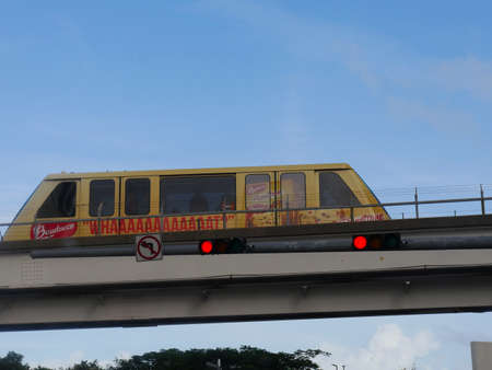 Miami, Florida- December 2018: A Metrorail transit zooms on the rail above the road in Miami.
