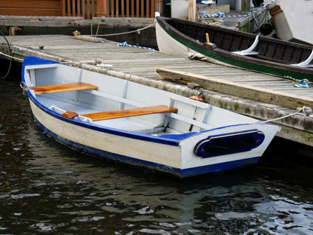 Small old wooden boats docked on the gang plank of the pier