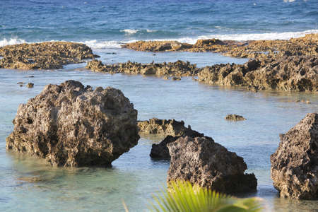 Sharp rocks and corals jutting out of the pristine beaches of Rota, Northern Mariana Islands