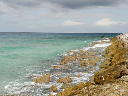 Clear waters of the ocean slapping gently over the sharp corals and rocks in a tropical islandの写真素材