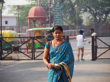 Agra, Uttar Pradesh, India- March 2018: A woman in traditional Indian attire stands outside the Red Fort in Agra.のeditorial素材