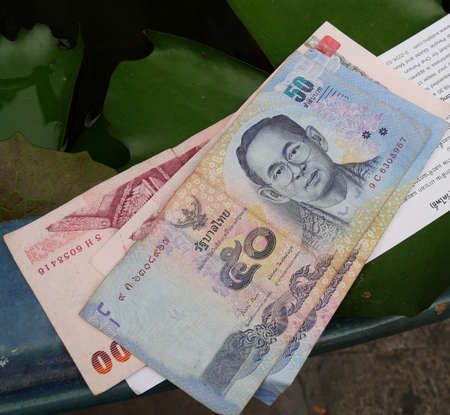 BANGKOK, THAILANDâMARCH 2016: Thailand currency bills, 50 and 100 baht bills on a tableのeditorial素材