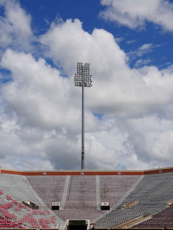 NORMAN, OKLAHOMAâShot of the Gaylord Family Oklahoma Memorial Stadium at the University of Oklahoma bleachers taken in March 2017 with overhead lights against blue and white skies backgroundのeditorial素材