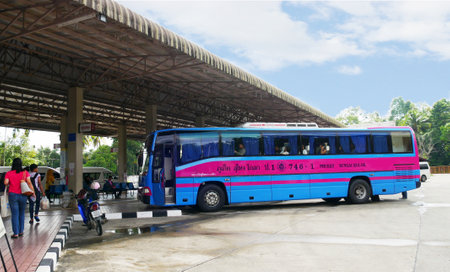 NARATHIWAT, THAILANDâ€”A blue and pink bus parks at the Narathiwat Bus Terminal in the...