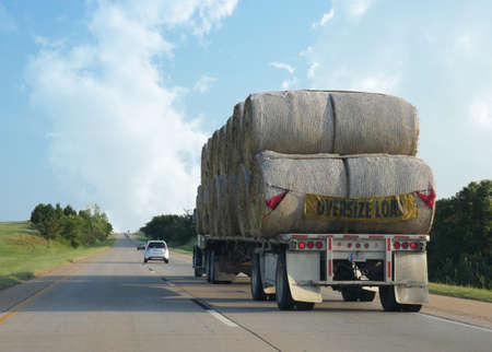 MOBILE, ALABAMAâA truck carrying an oversize load of hay bales travelling along the interstate in Mobile, Alabama in September 2015.のeditorial素材