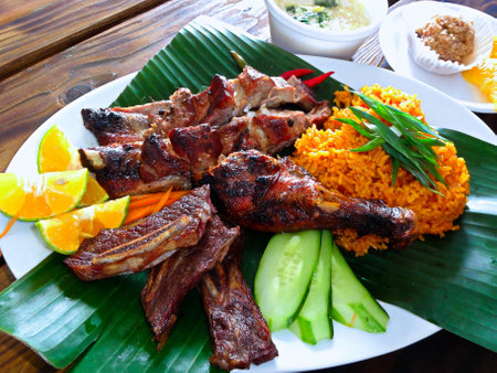 Thai style grilled pork ribs served with rice, orange and cucumberの写真素材