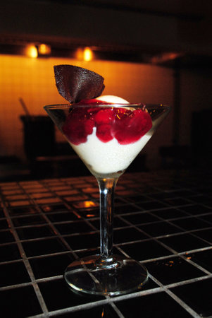 Ice cream with raspberries in a martini glass on the table.の写真素材