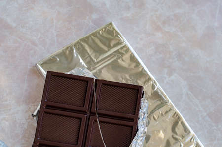 Chocolate bar pieces on marble table