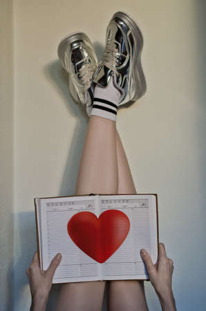 woman holding notebook with red heart signの写真素材