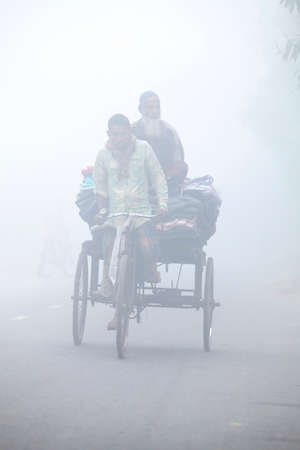 Bangladesh â€“ January 06, 2014: On a foggy winter morning, some village people going to work...